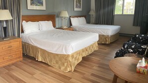 A hotel room with two beds, a wooden dresser, a table with a tissue box, and curtains. - Motel Jann (Québec City)
