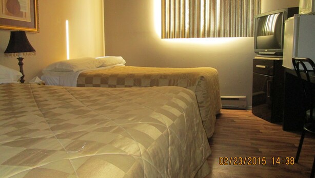 A hotel room with two beds, a television, a desk, and a window with curtains. - Motel Lustre d'Or (Québec City)