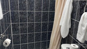 A bathroom with a toilet, bidet, and a shower curtain. - Motel Lustre d'Or (Québec City)