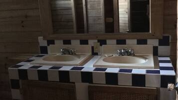 A bathroom with two sinks, a mirror, and a checkered tile backsplash.