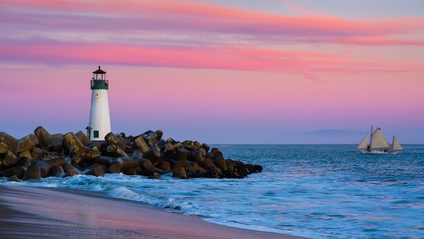 A lighthouse on a rocky outcrop with the ocean in the background. - Harbor Inn (Santa Cruz)