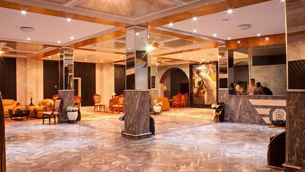 A spacious lobby with marble flooring, multiple seating areas, and a reception desk. - Royal Suites (Nouakchott)