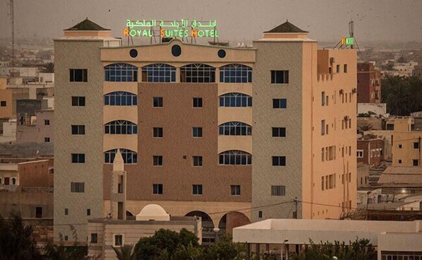 A multi-story hotel with a prominent sign reading "ROYAL SUITES HOTEL" in Arabic. - Royal Suites (Nouakchott)