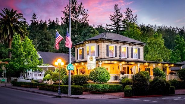 A historic building with a well-maintained facade, a prominent sign indicating 'Embrace California 128', and a flagpole with an American flag. - Embrace Calistoga (Calistoga)