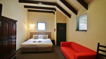 Relax in a spacious room with a large bed, sofa, and wardrobe.
