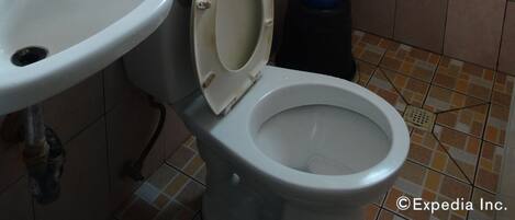 A bathroom with a toilet, sink, and shower.
