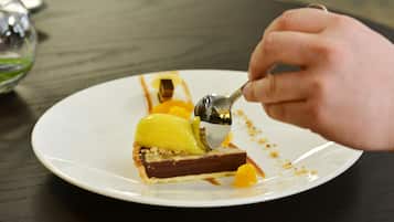 Un dessert servi dans une assiette blanche, accompagné d’une cuillère.