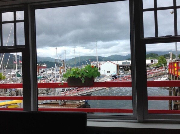 A view from a window with a red railing, overlooking a marina with boats and a mountainous backdrop. - Eagle Bluff Bed & Breakfast (Prince Rupert)