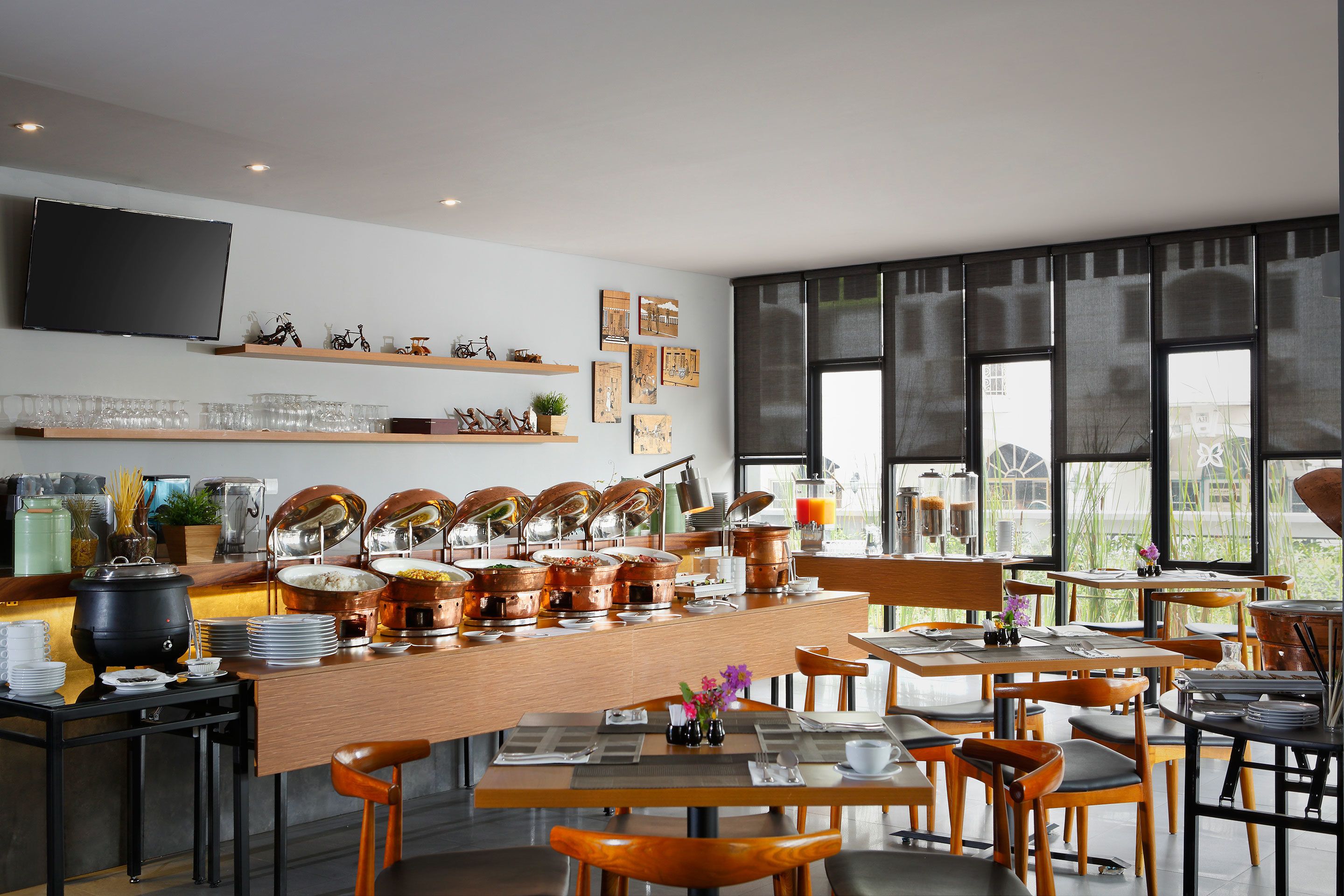 A modern dining area with a long counter, multiple seating options, and a large window providing natural light.
