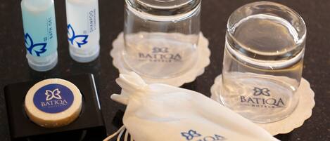 A set of toiletries including a soap bar, two tubes, and two glasses, all branded with 'Batiqa Hotels'.