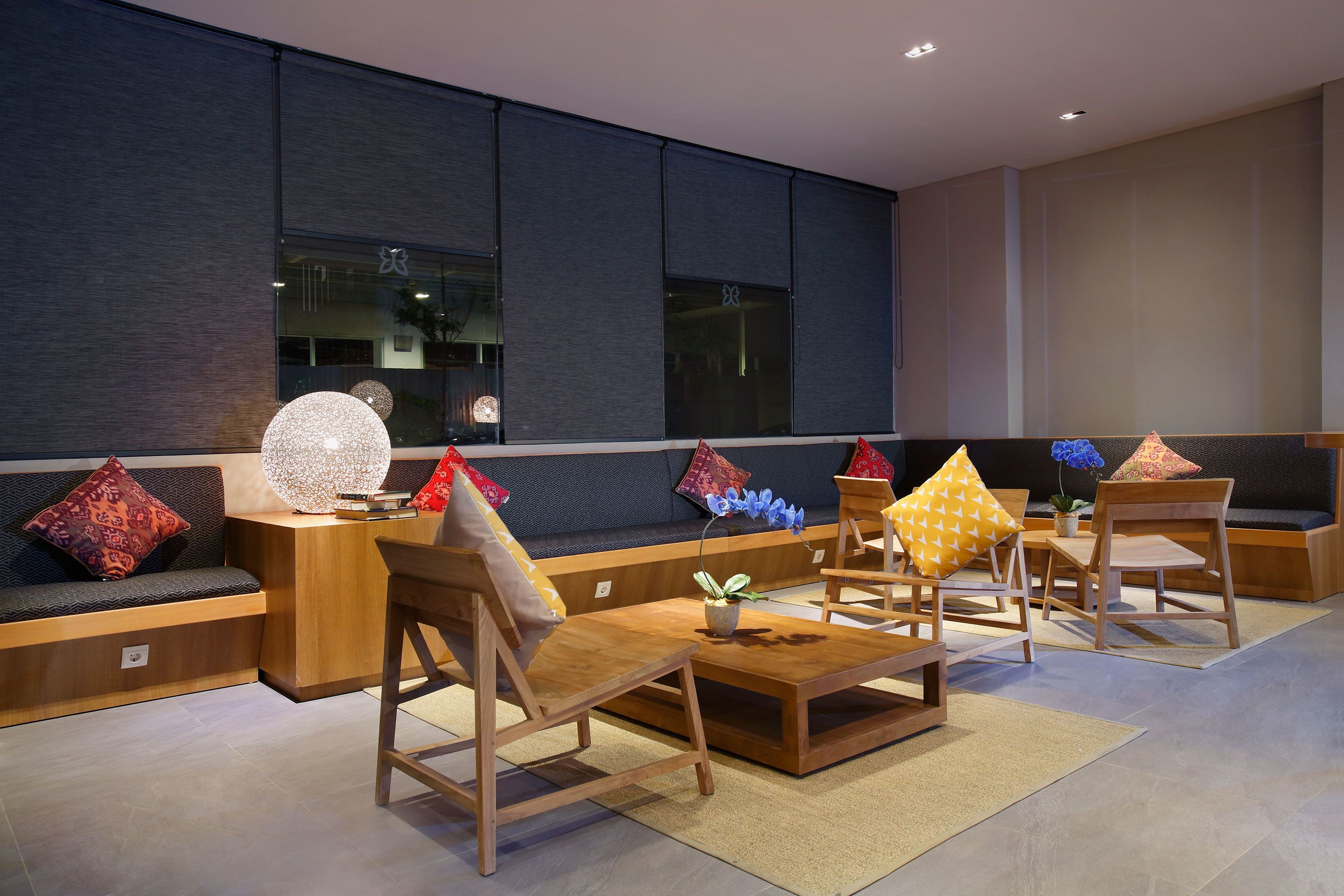 A modern interior with a seating area featuring wooden furniture and decorative pillows.