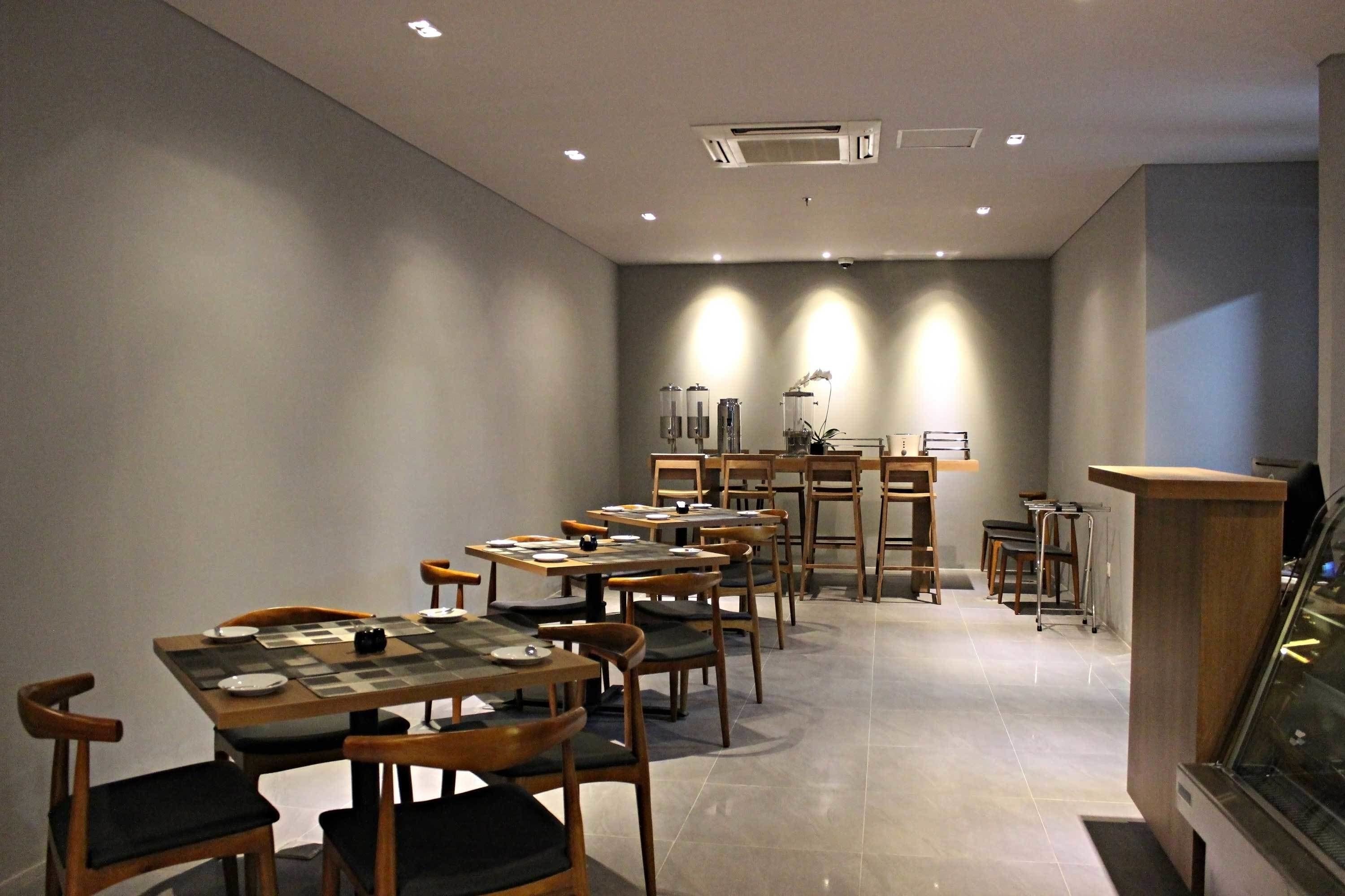 A dining area with multiple tables and chairs, a counter, and a display case.