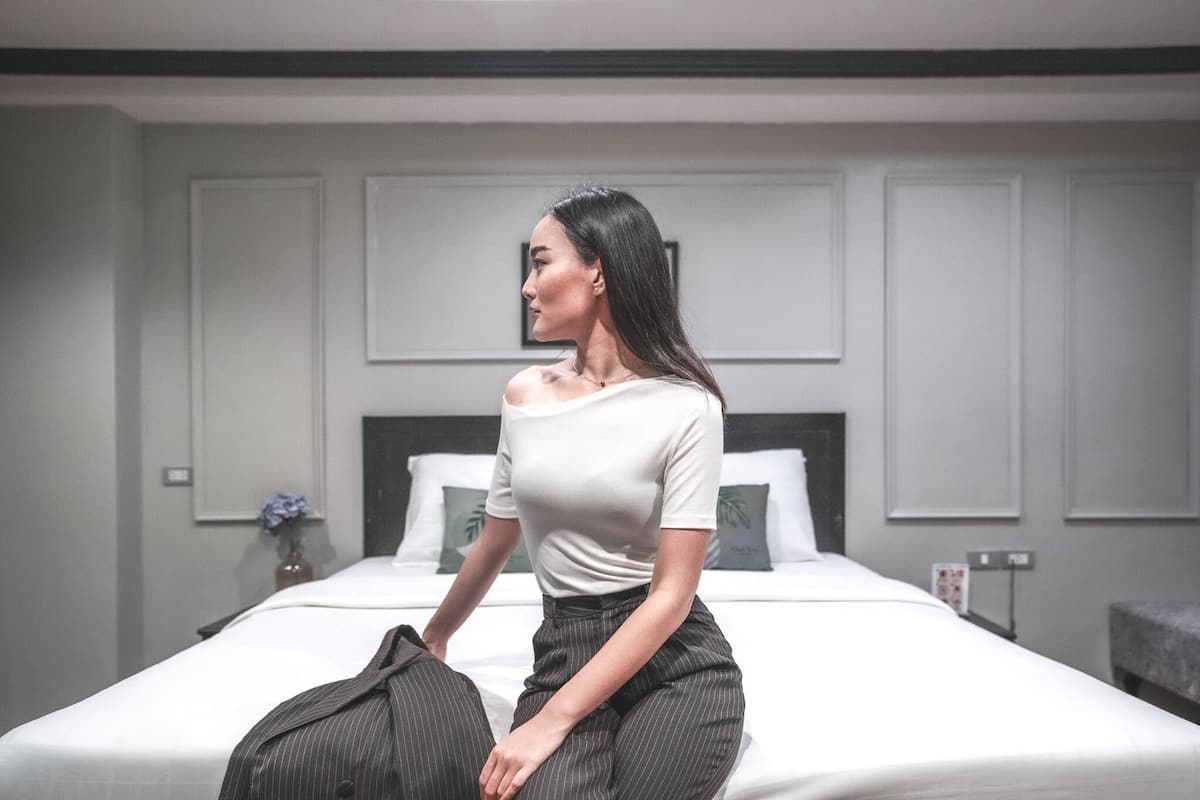 A hotel room with a bed, a bedside table, and a wall-mounted picture frame.