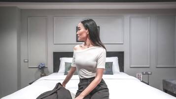 Habitación de hotel con cama, mesita de noche y un cuadro colgado en la pared.