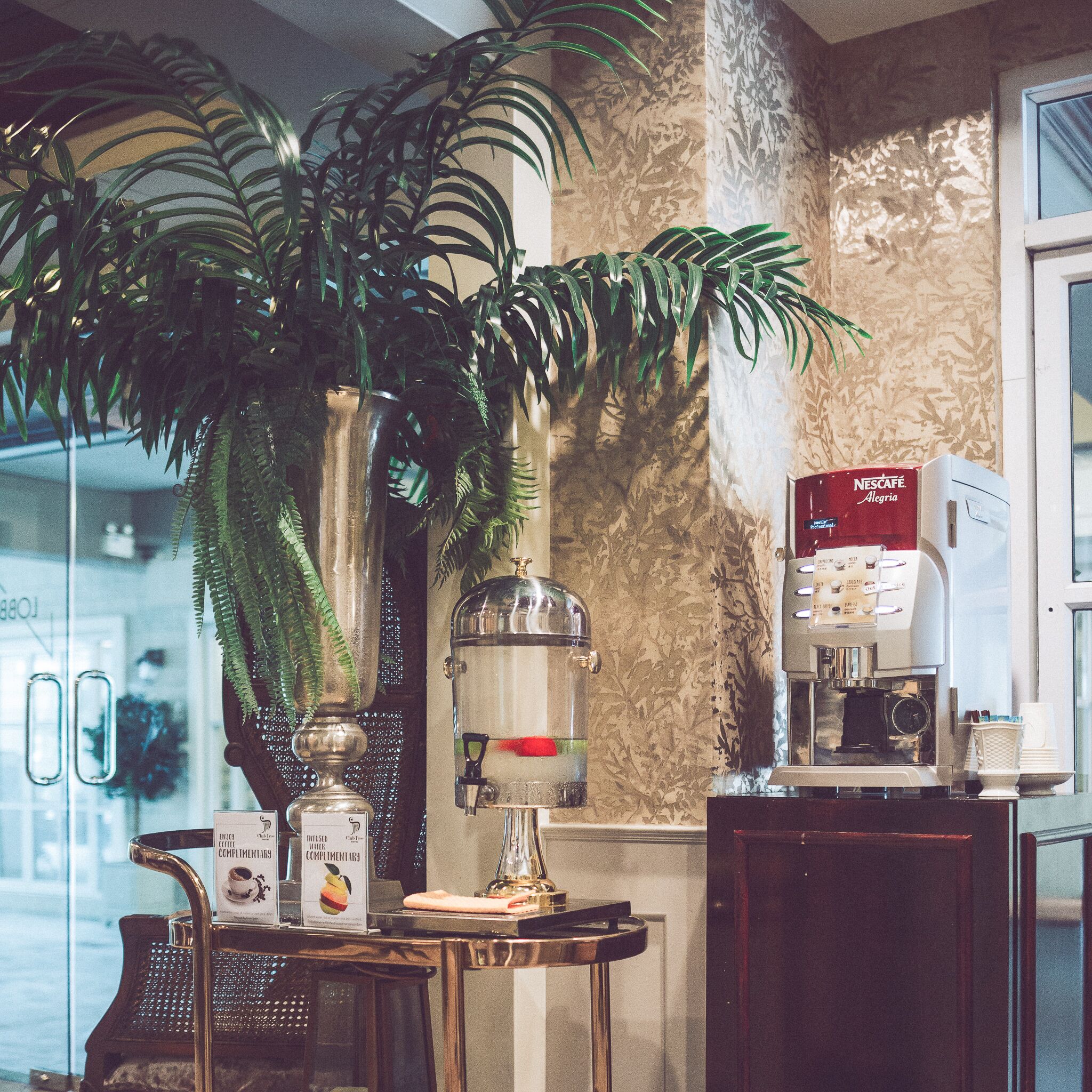 A coffee station with a water dispenser, a coffee machine, and a menu board.