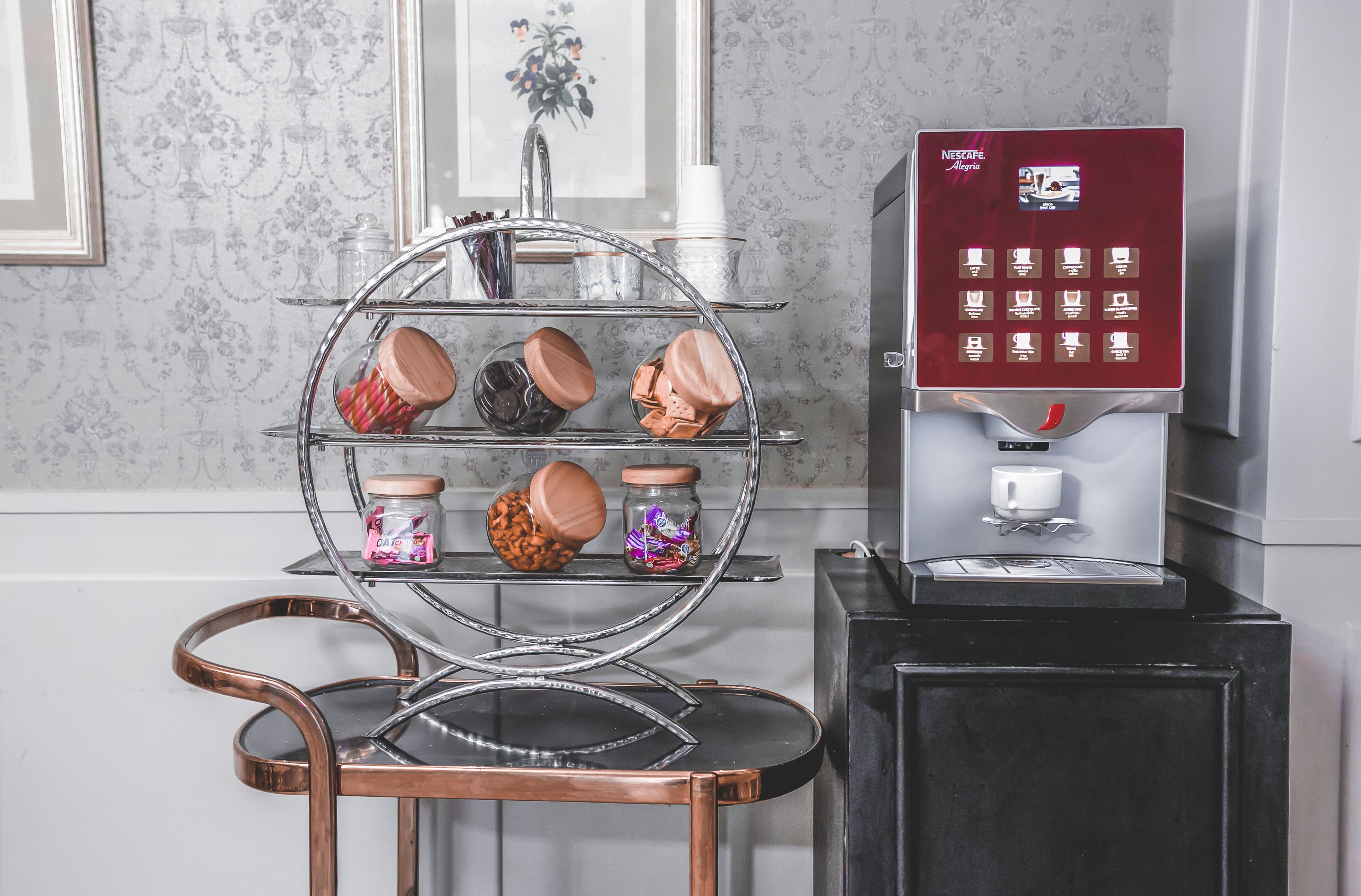 A coffee machine with a selection of mugs and containers on a metal stand.