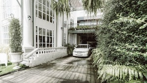 A white building with large windows and a car parked in front. - Club Tree Hotel (Songkhla)