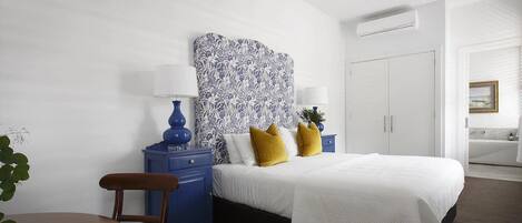 A bedroom with a bed, bedside tables, a chair, and a nightstand.