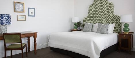 Een keurig opgemaakt slaapkamer met een bed, bureau en stoel.