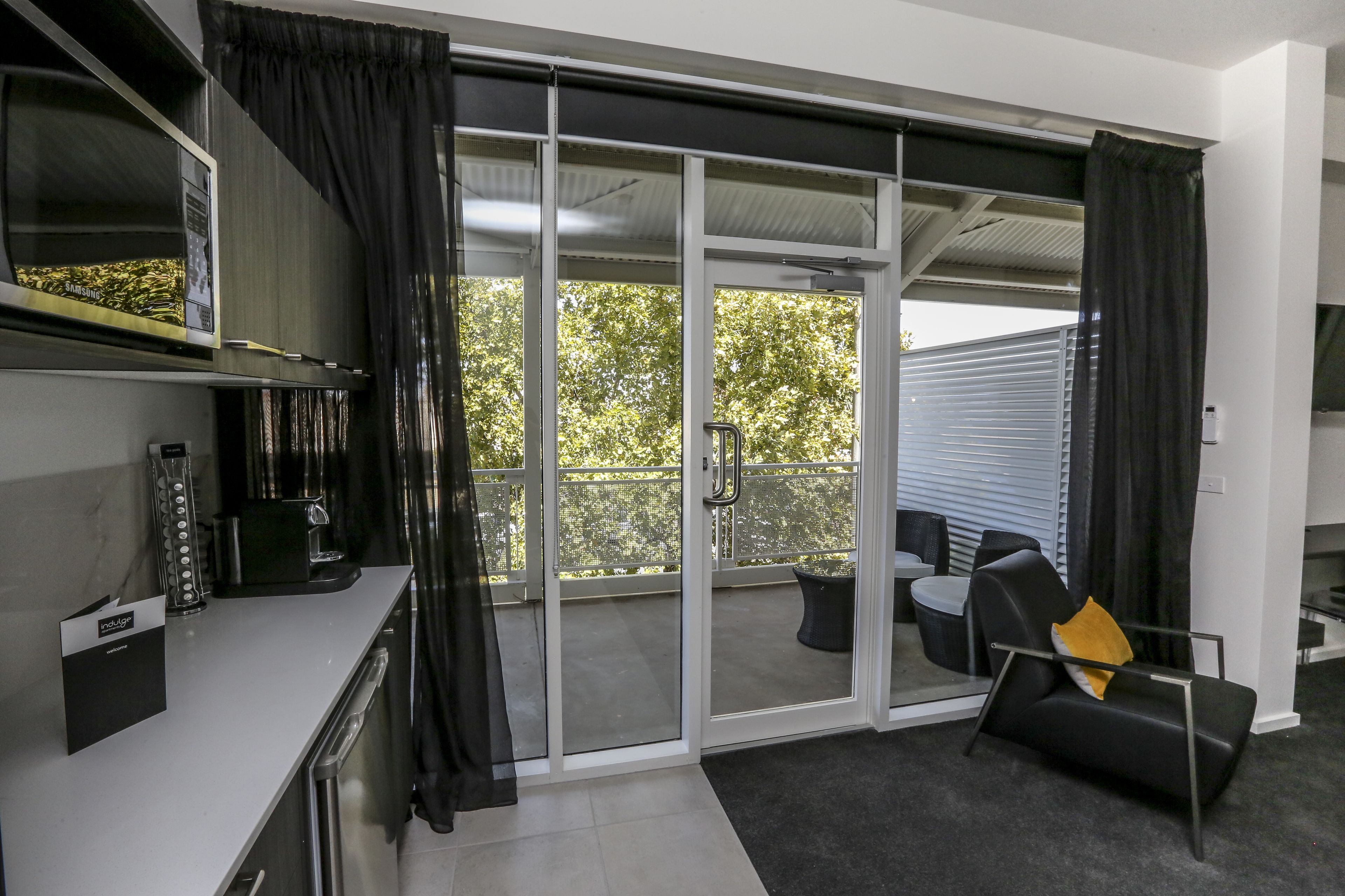 Una cocina moderna equipada con microondas, cafetera y un refrigerador Samsung.