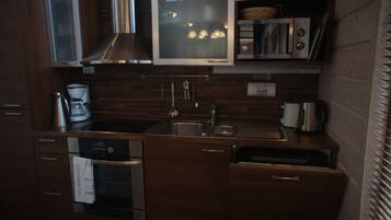 A modern kitchen with stainless steel appliances, wooden cabinetry, and a built-in microwave.