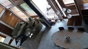 Un salón amplio con una mesa redonda, varias sillas, un sofá y un ventilador de techo.