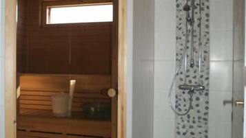 Un sauna avec un banc en bois, une petite fenêtre et un espace douche avec un mur carrelé.