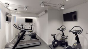 A modern gym with treadmills, stationary bikes, and a mirrored wall. - VISIONAPARTMENTS Berlin Otto-Braun-Strasse (Berlin)