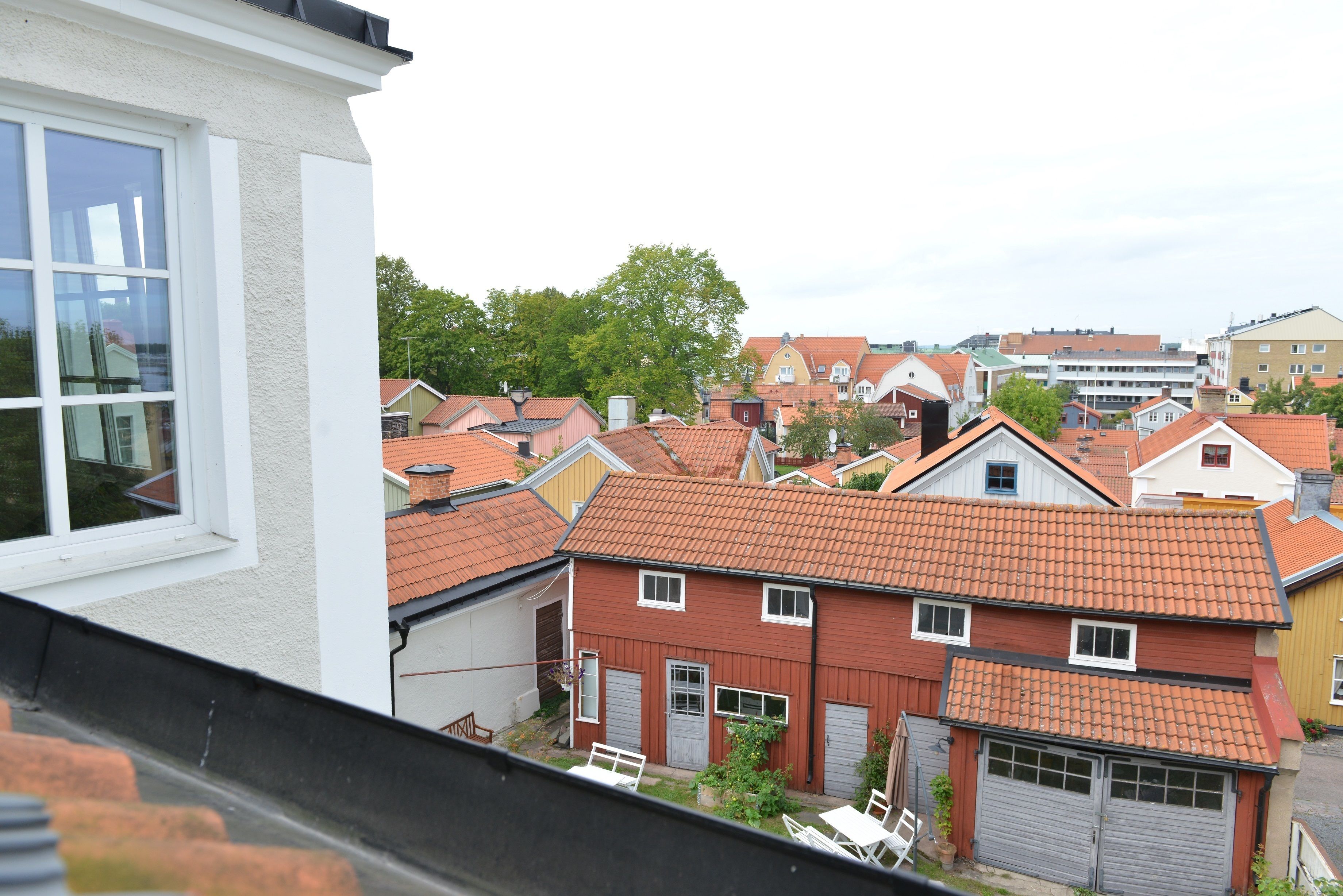 A residential area with houses featuring red-tiled roofs and white walls.