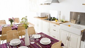 A modern kitchen with white cabinets, a wooden countertop, and a built-in stove. - Casa Babel Monfragüe (Torrejon El Rubio)