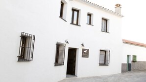 A white building with multiple windows, a door, and a sign that reads "CASA BABEL MONFRAGUE". - Casa Babel Monfragüe (Torrejon El Rubio)