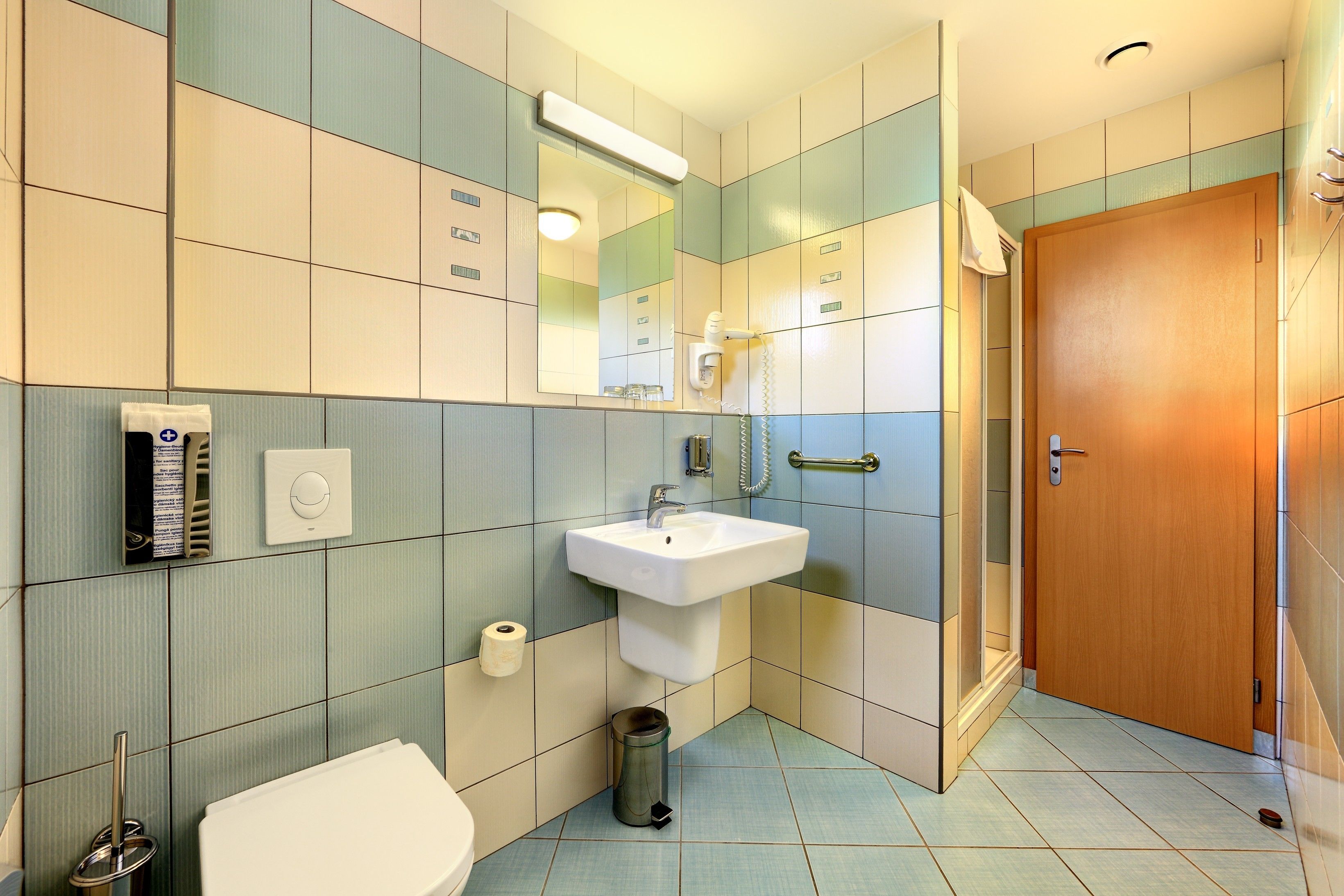 Een badkamer met een wastafel, toilet en spiegel.