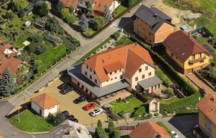 Vista aérea de una zona residencial con casas, un pequeño aparcamiento y un espacio verde con un parque infantil.