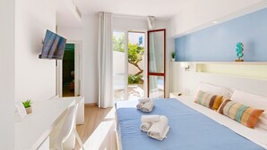 A hotel room with a bed, a TV, a desk, and a view of the outside. - Hotel Perla Gaia (San Vito Lo Capo)