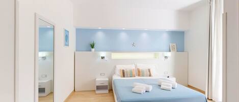 A modern bedroom with a bed, bedside tables, a nightstand, a mirror, and a wall-mounted star decoration.