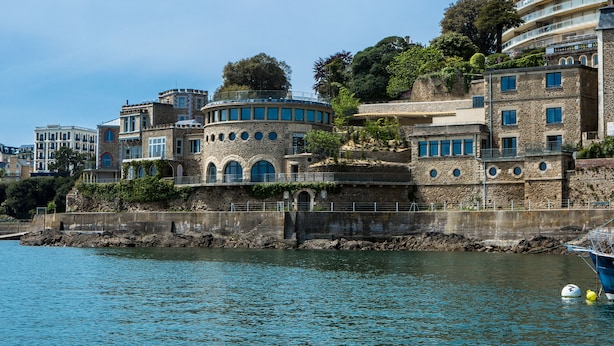 A coastal building with multiple balconies, a stone facade, and a view of the sea. - Castelbrac Hôtel & Spa (Dinard)