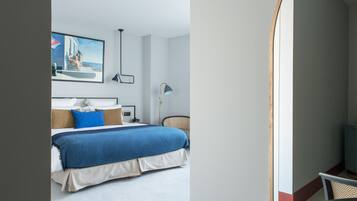 Une chambre à coucher moderne avec un lit, un tableau, un bureau et une chaise.