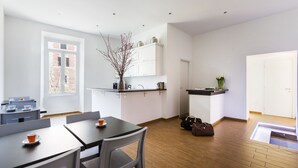A modern kitchen with white cabinets, a black countertop, and a window providing natural light. - Rest Guesthouse (Rome)
