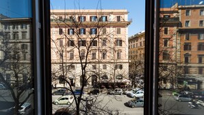 A multi-story building with a central courtyard and a street view through a window. - Rest Guesthouse (Rome)