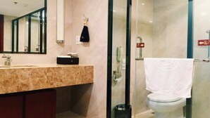 A modern bathroom with a marble countertop, a glass shower enclosure, and a white toilet. - Antai Century Hotel (Chengdu)