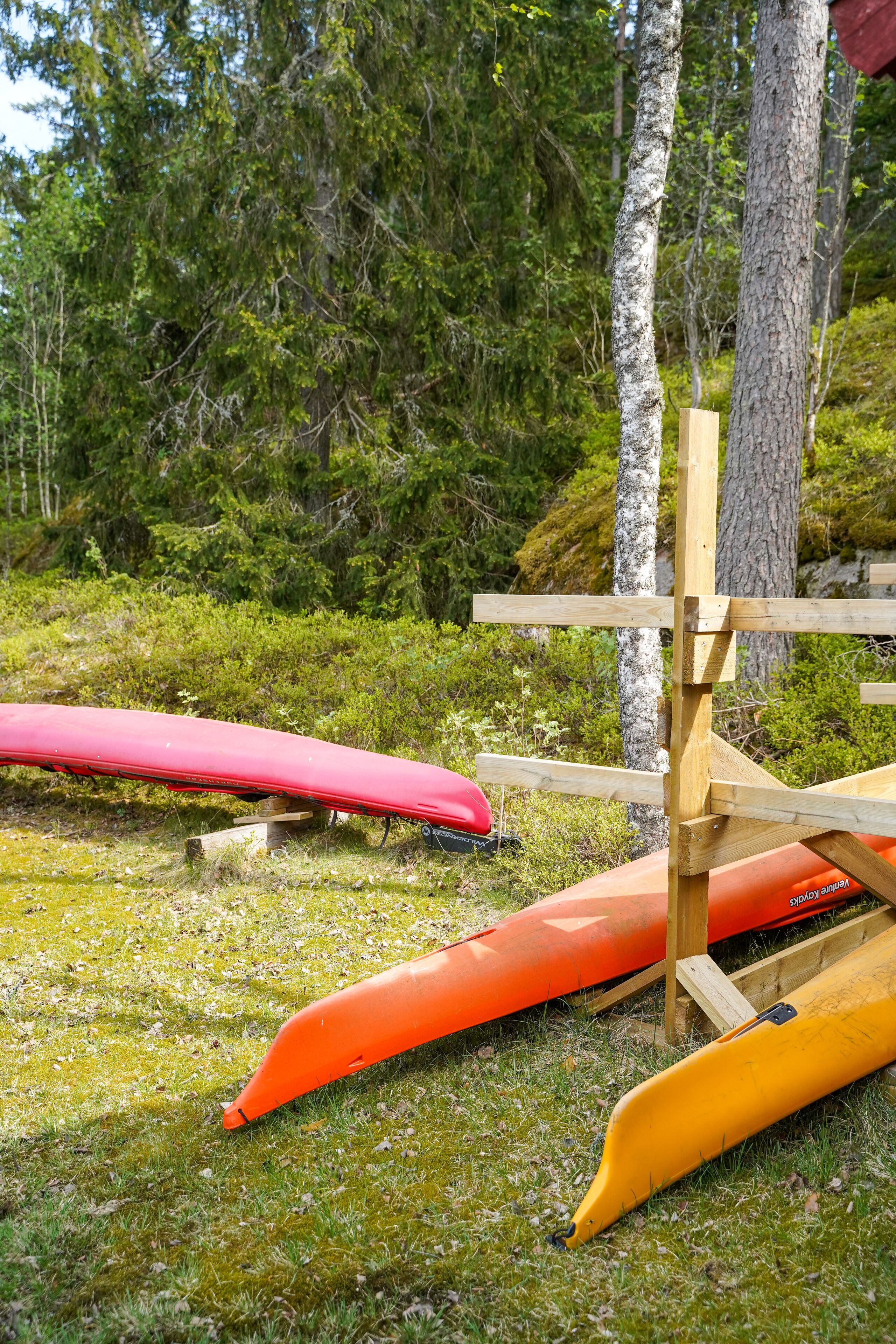 Een houten constructie met kajaks ertegen.