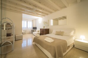Un dormitorio amplio con una cama grande, un armario, un escritorio y una silla.