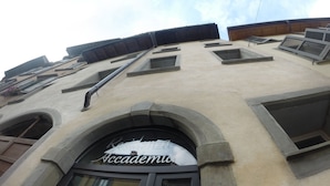 A building with a sign reading "Residency Academy." It features multiple windows and a large arched entrance.