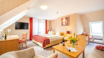 Ein Hotelzimmer mit Bett, Schreibtisch, Stuhl und Fernseher.