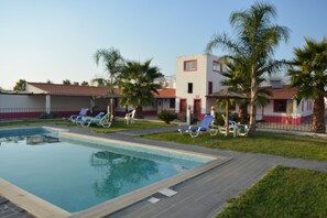 2 ulkouima-allasta, aurinkovarjoja, aurinkotuoleja