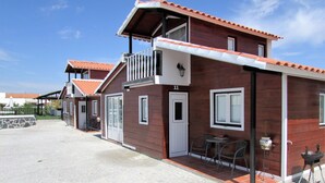 A two-story wooden building with a balcony, a door, and a window. - Lusitaurus (Redondo)