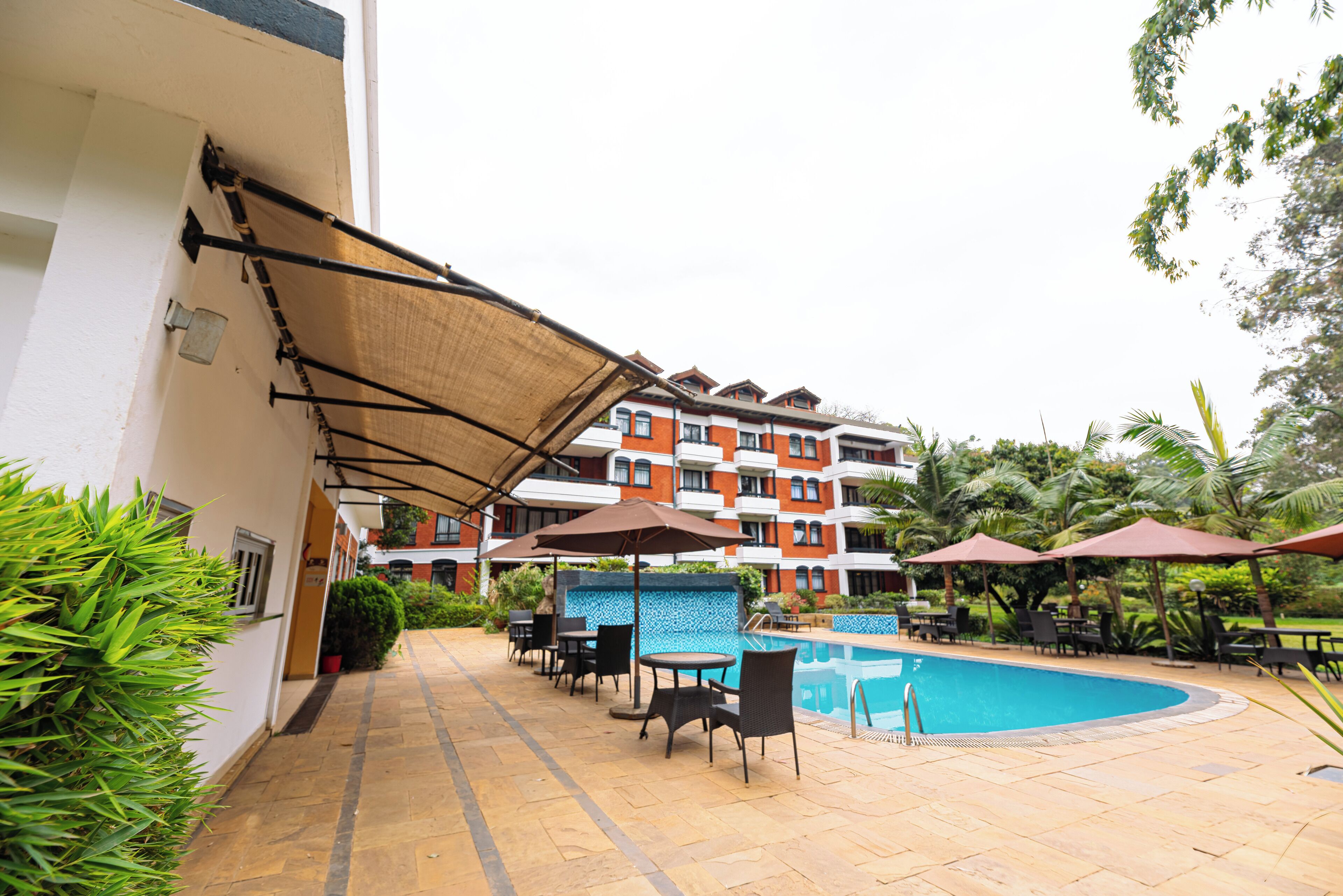 A poolside area with outdoor seating and a building in the background.