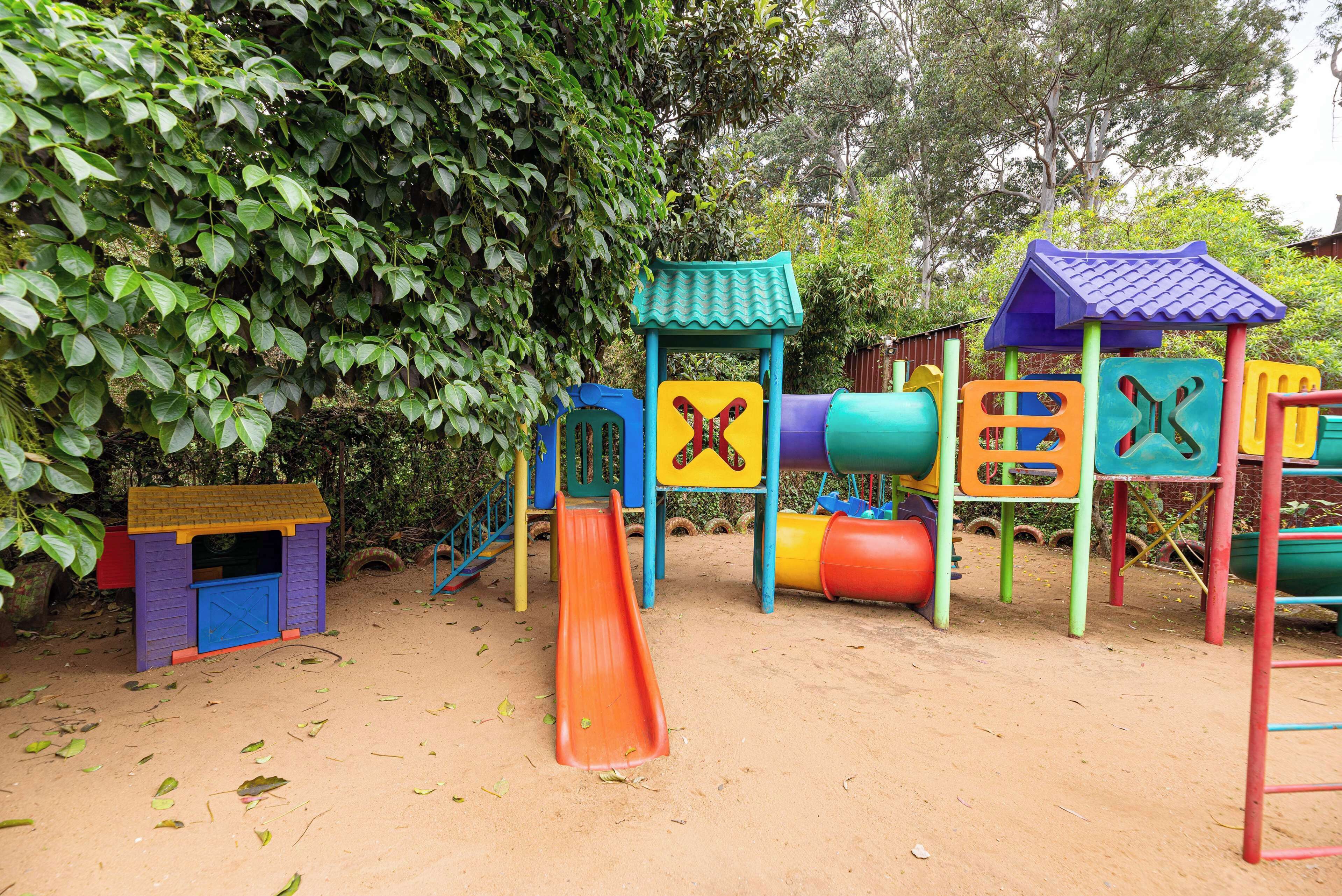 Un parque infantil con diversas estructuras de juego, incluyendo toboganes y zonas de escalada.
