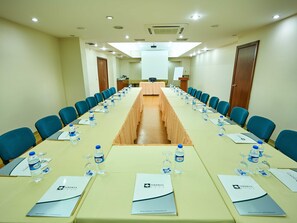 A conference room with a long table, blue chairs, water bottles, and nameplates. - Feronya Hotel (Istanbul)