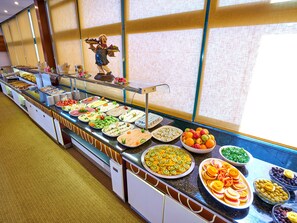 A buffet with various food items and a decorative statue. - Feronya Hotel (Istanbul)